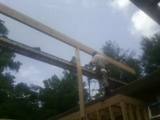 Carpenter setting a ridge beam over a new addition frame — Ice Dam Removal by Roofing Brothers in Kimberly